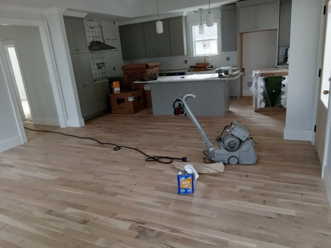 Drum sander on new white oak in an open kitchen and living area