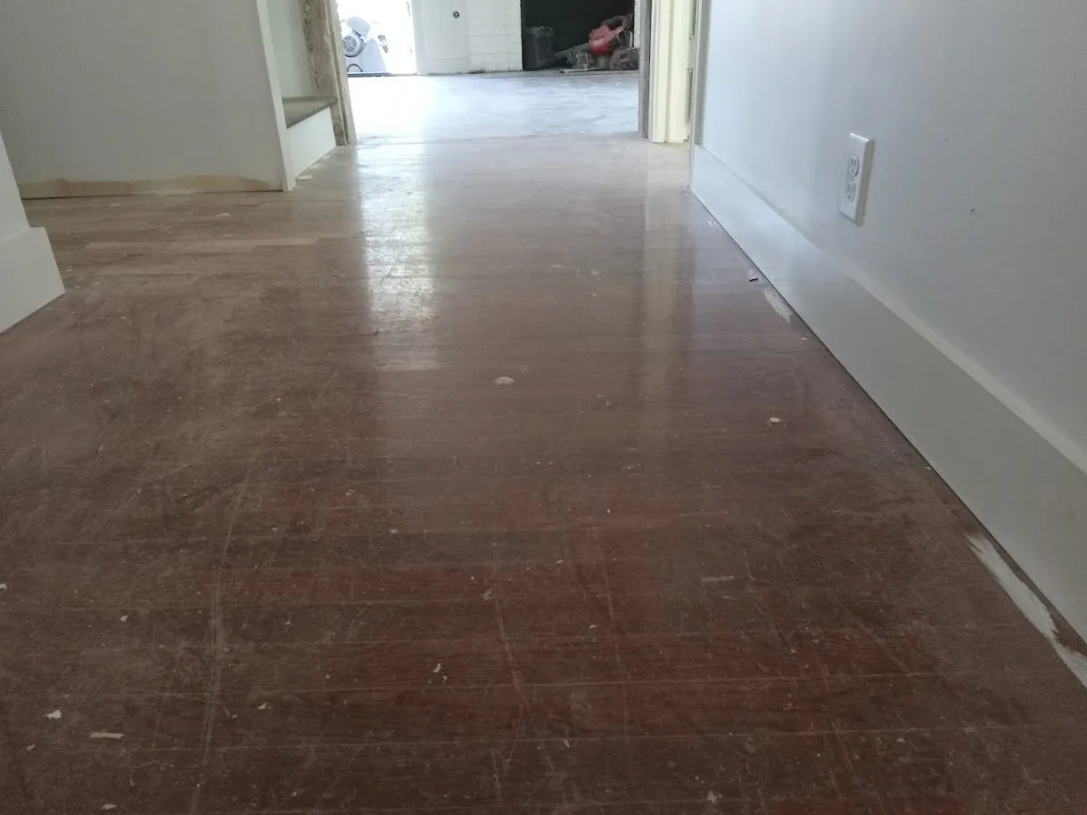 Scratched, cherry-stained hallway floor before refinishing