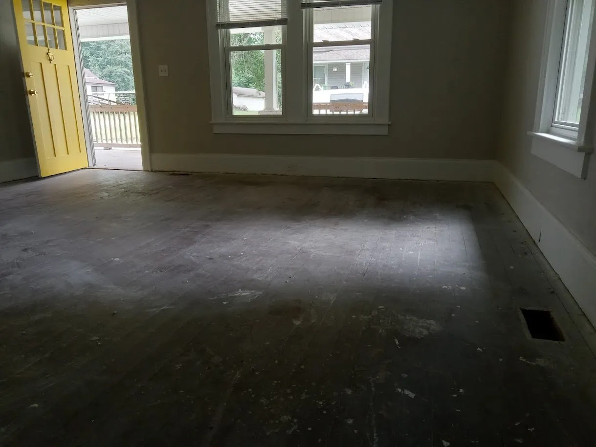 Heart pine floor covered in dark paint and old stain before refinishing