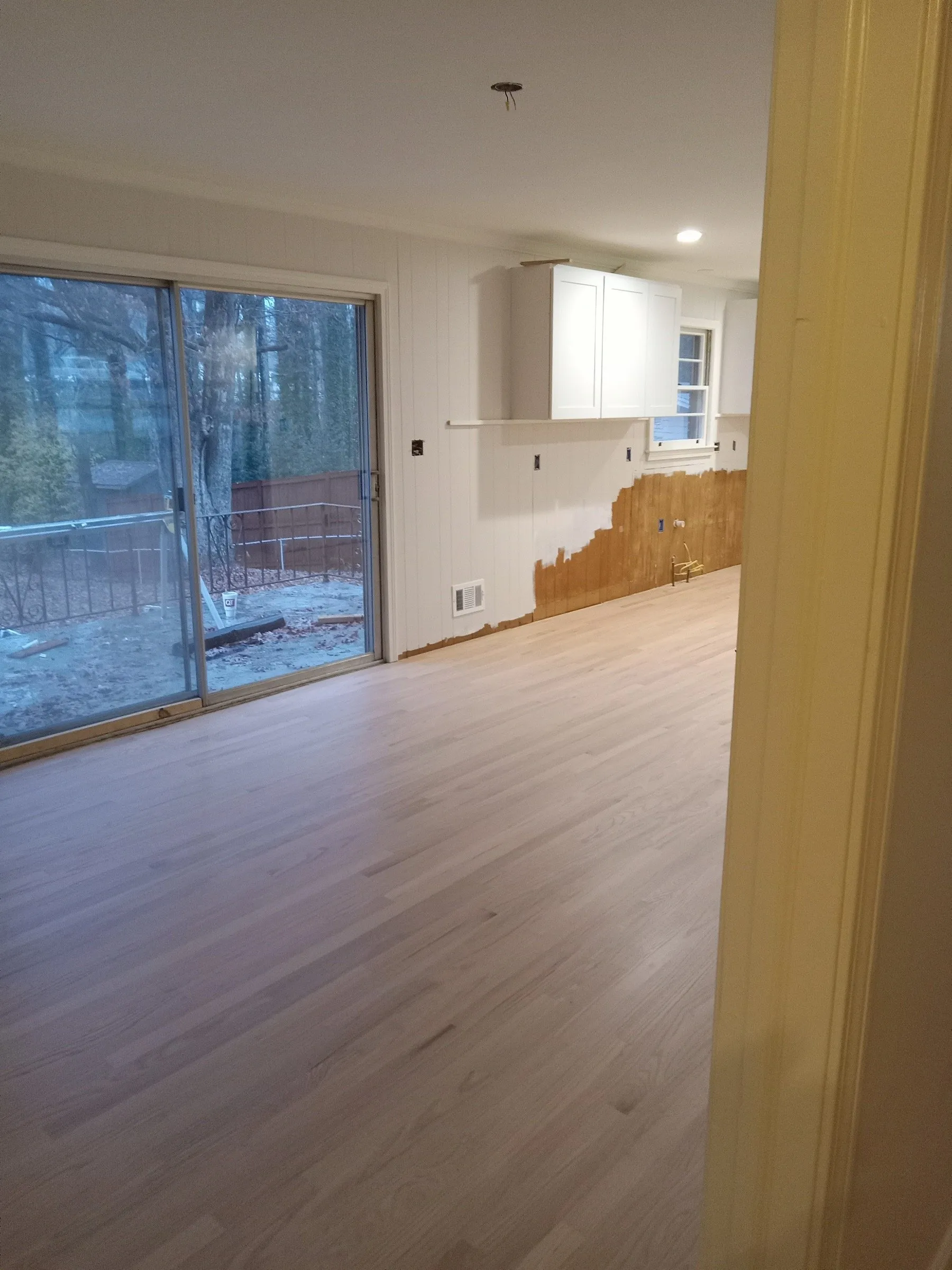 Natural oak floor in the new kitchen addition beside a sliding glass door