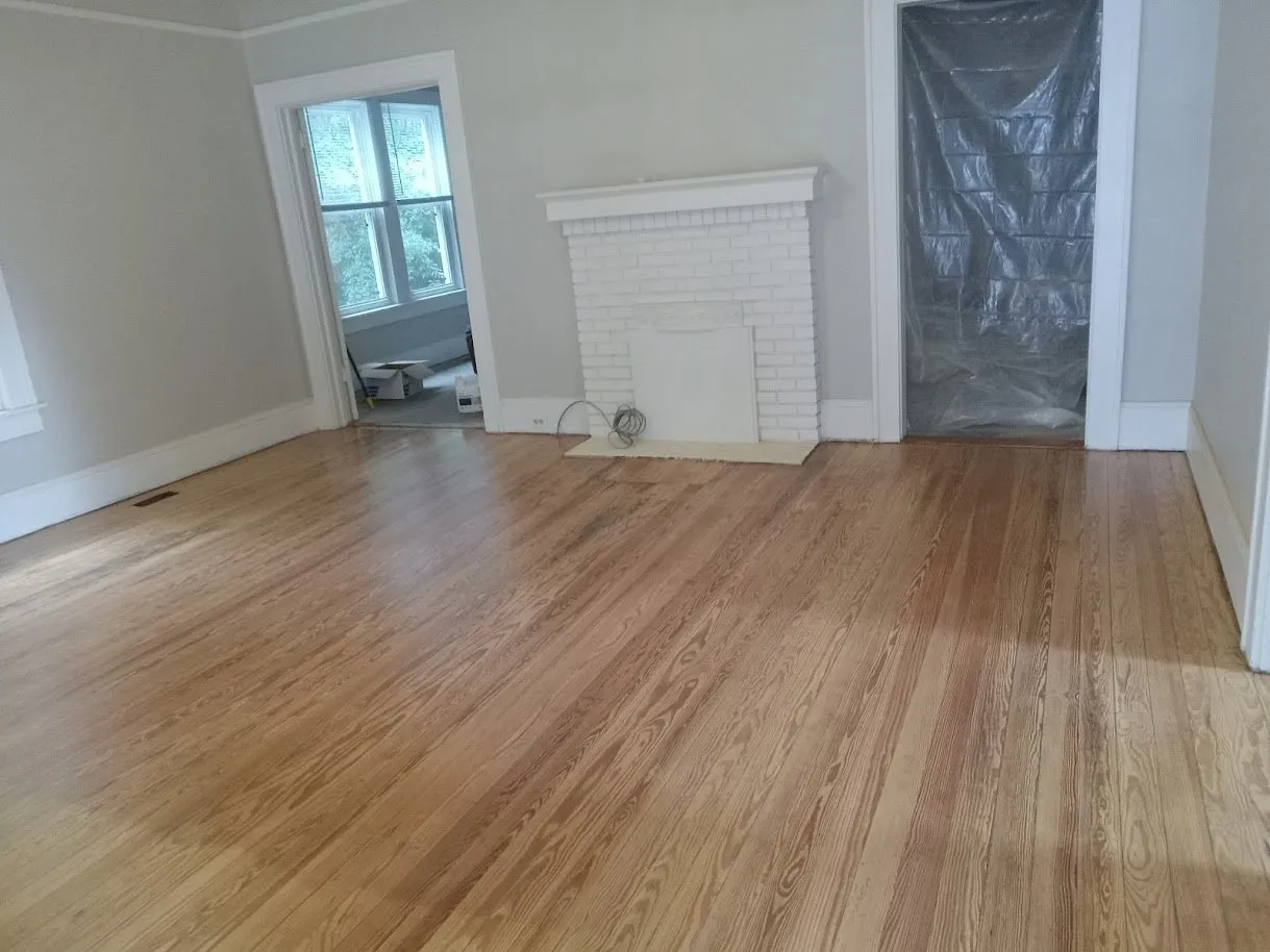 Refinished heart pine floor in front of a white brick fireplace